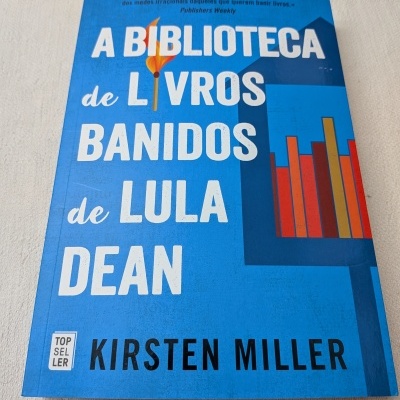 Livro azul intitulado A Biblioteca de Livros Banidos de Lula Dean com gráfico colorido na capa.