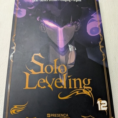 Capa do livro Solo Leveling volume 12 com personagem e texto em dourado sobre fundo negro e roxo
