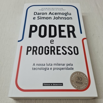 Livro 'Poder e Progresso' de capa branca com texto a preto e linhas a azul e vermelho.