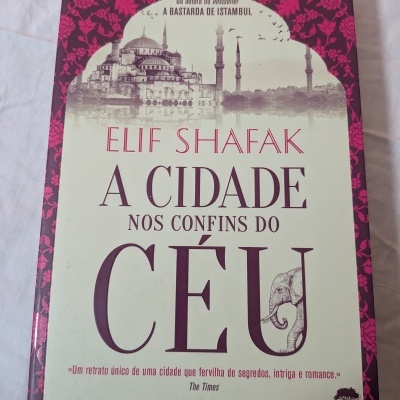 Capa de livro 'A Cidade Nos Confins do Céu' de Elif Shafak com imagem de mesquita e corre elfo