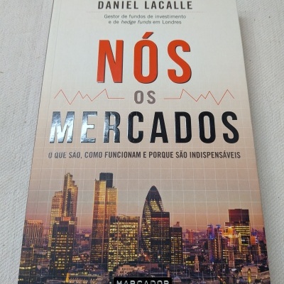 Capa do livro NÓS OS MERCADOS de Daniel Lacalle com imagem de prédios ao pôr do sol