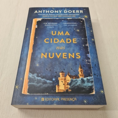 Livro UMA CIDADE nas NUVENS com capa azul estrelada e castelo nas nuvens