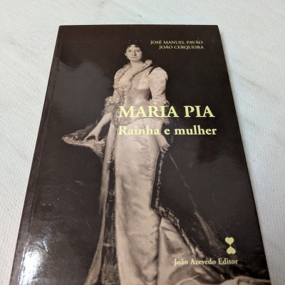 Livro Maria Pia Rainha e mulher com capa marrom e imagem de mulher vestida com vestido antigo