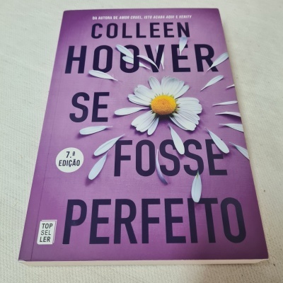Livro 'Se Fosse Perfeito' de Colleen Hoover com capa roxa e margarida desenhada
