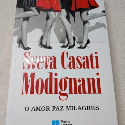 Capa de livro com imagem em preto e branco de pernas femininas com vestidos vermelhos e pretos e texto do título e autor.