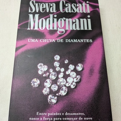 Capa de livro roxa e preta com texto branco e diamantes desenhados.
