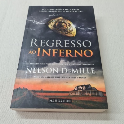 Capa do livro 'Regresso ao Inferno' de Nelson DeMille com distintivo policial e casa ao pôr do sol