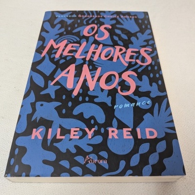 Livro 'OS MELHORES ANOS' com capa azul e preta com letras rosa