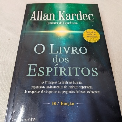 Capa do livro O Livro dos Espíritos de Allan Kardec com fundo azul esverdeado e texto branco e amarelo.