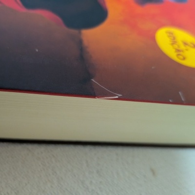 Livro encadernado colorido com autocolante amarelo 2ª EDIÇÃO sobre superfície clara