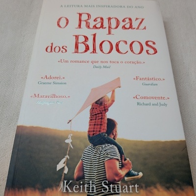 Capa do livro o Rapaz dos Blocos com homem e criança ao pôr do sol.