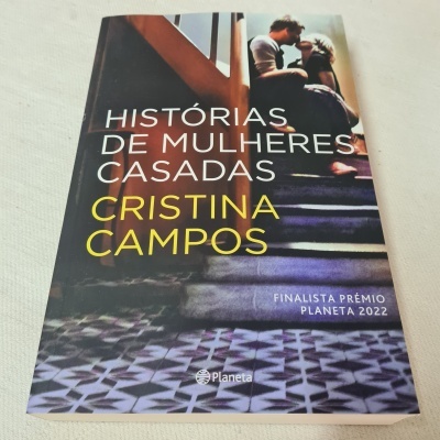 Capa do livro 'Histórias de Mulheres Casadas' de Cristina Campos, com casal em escadas e textos visíveis.
