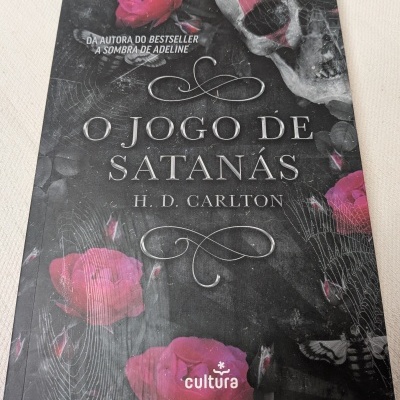 Capa do livro O Jogo de Satanás com caveira, rosas e teias de aranha