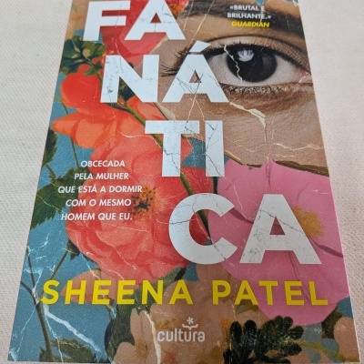 Capa de livro com palavra FANÁTICA, flores coloridas e olho humano em fundo