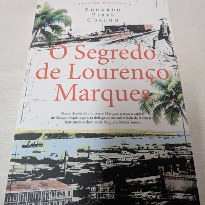 Capa de livro O Segredo de Lourenço Marques com desenhos de palmeiras e cidade