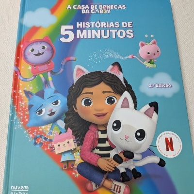 Capa de livro infantil azul com personagens e arco-íris, texto sobre histórias e Netflix.