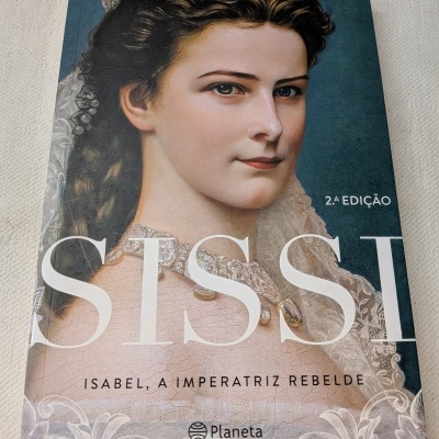 Livro Sissi Isabel, a Imperatriz Rebelde capa com retrato de mulher jovem e detalhes em renda branca.