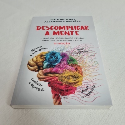 Capa do livro Descomplicar a Mente com ilustração colorida de cérebro em cordas