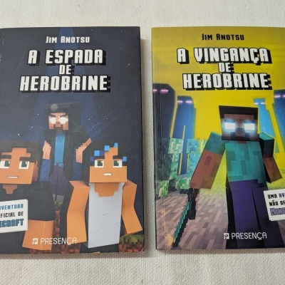 Duas capas de livros estilo Minecraft com títulos em português, fundo preto e amarelo, sobre mesa clara.