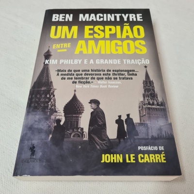 Capa de livro 'Um espião entre amigos' de Ben Macintyre com imagens de silhuetas e edifícios russos