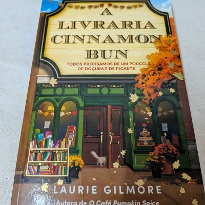 Capa do livro A LIVRARIA CINNAMON BUN com fachada de livraria verde e árvores outonais