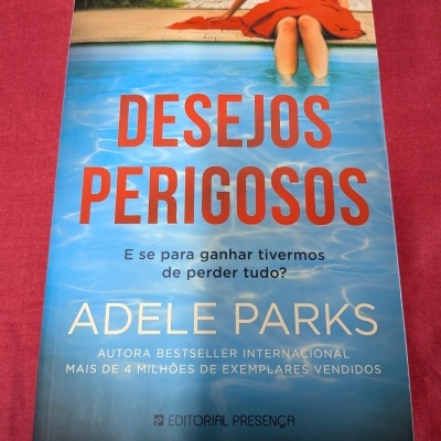 Capa do livro Desejos Perigosos de Adele Parks com mulher de vestido vermelho junto a piscina