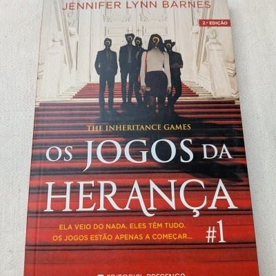Capa do livro Os Jogos da Herança com escadaria vermelha e figuras humanas.