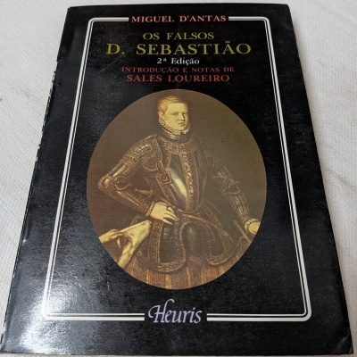 Capa de livro preta com texto e imagem de figura histórica vestindo armadura dourada