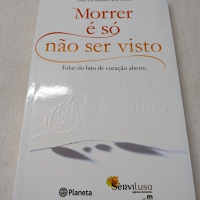 Capa branca de livro Morrer é só não ser visto de Inês de Barros Baptista com logotipos Planeta e Servilusa