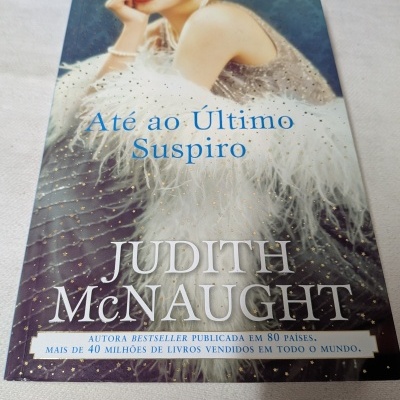 Capa de livro vermelho e azul com mulher loira de vestido e casaco branco peludo