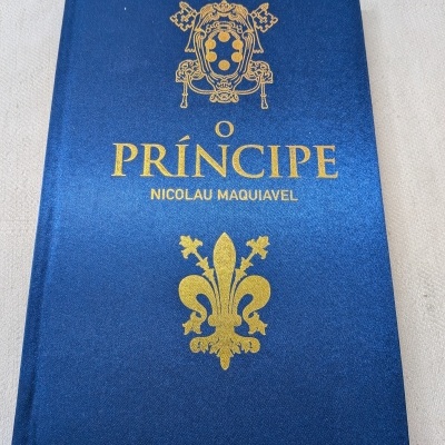 Livro de capa dura azul com título dourado O PRÍNCIPE de NICOLAU MAQUIAVEL
