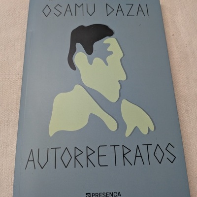 Capa de livro azul claro com ilustração de rosto abstrato e texto AUTORRETRATOS de Osamu Dazai