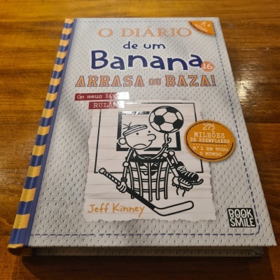 Livro 'O Diário de um Banana 16' com capa dura e ilustração de personagem em fundo cinza e azul