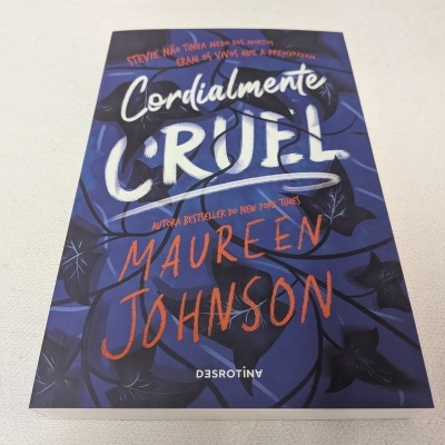 Capa de livro azul com texto 'Cordialmente CRUEL', 'Maureen Johnson' e 'EDITORA DESROTINY'