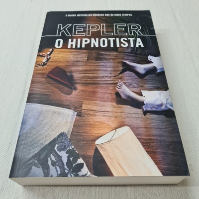 Livro 'O Hipnotista' de Kepler com capa ilustrando chão, pés e objetos