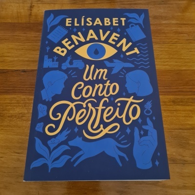 Livro 'Um conto perfeito' de Elísabet Benavent com capa azul escura e ilustrações amarelas.