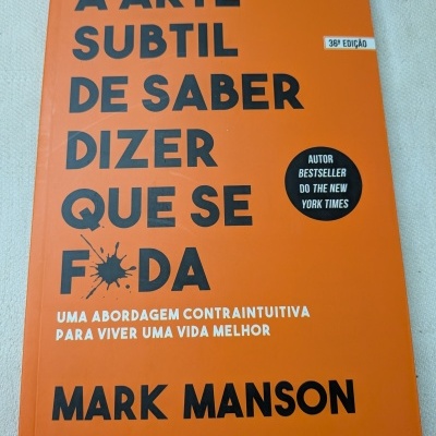 Capa de livro laranja com texto preto e branco
