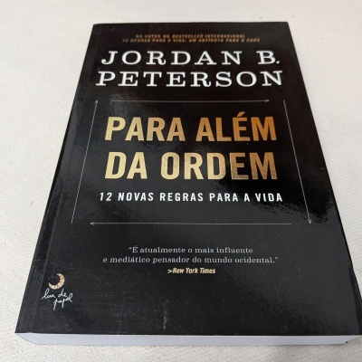 Livro 'Para Além da Ordem' de Jordan B. Peterson com capa preta e texto amarelo e branco
