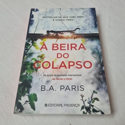 Capa do livro 'À Beira do Colapso' com plantas verdes e texto em vermelho e preto