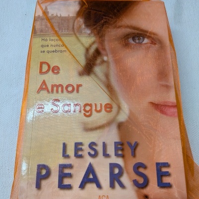 Livro De Amor e Sangue de Lesley Pearse numa capa com rosto feminino dentro de saco laranja translúcido