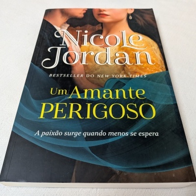 Livro 'Um Amante Perigoso' de Nicole Jordan com imagem de casal na capa