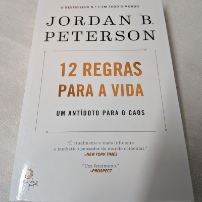 Livro 12 Regras Para a Vida de Jordan B. Peterson sobre tecido bege claro