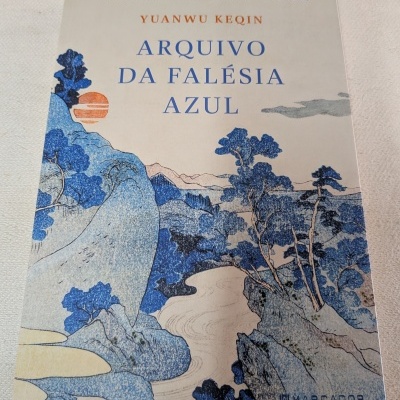 Capa de livro com ilustração de paisagem em azul e laranja e texto em português.