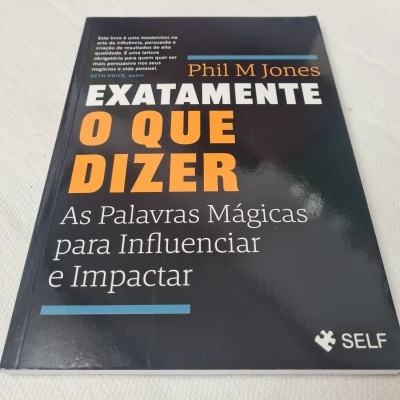 Capa do livro 'Exatamente O Que Dizer' de Phil M Jones com fundo preto e texto em branco e laranja