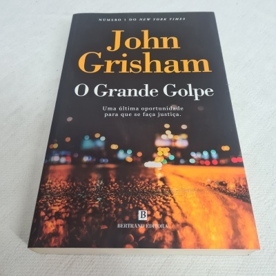 Capa do livro 'O Grande Golpe' de John Grisham com imagem de luzes em fundo escuro