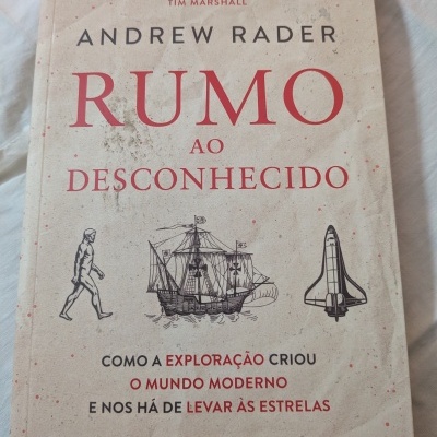 Capa do livro 'Rumo ao Desconhecido' com ilustrações e texto em vermelho e preto sobre fundo bege.