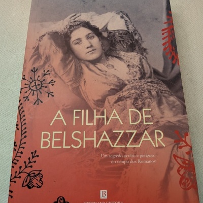 Capa de livro com fotografia em sépia de mulher reclinada e texto sobre o fundo vermelho