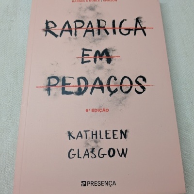 Livro RAPARIGA EM PEDAÇOS de Kathleen Glasgow sobre superfície branca.