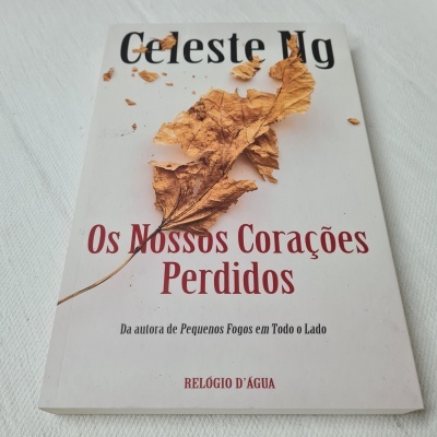 Livro 'Os Nossos Corações Perdidos' de Celeste Ng com uma folha seca na capa