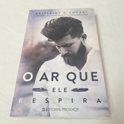 Livro com capa mostrando homem de barba e título O AR QUE ELE RESPIRA
